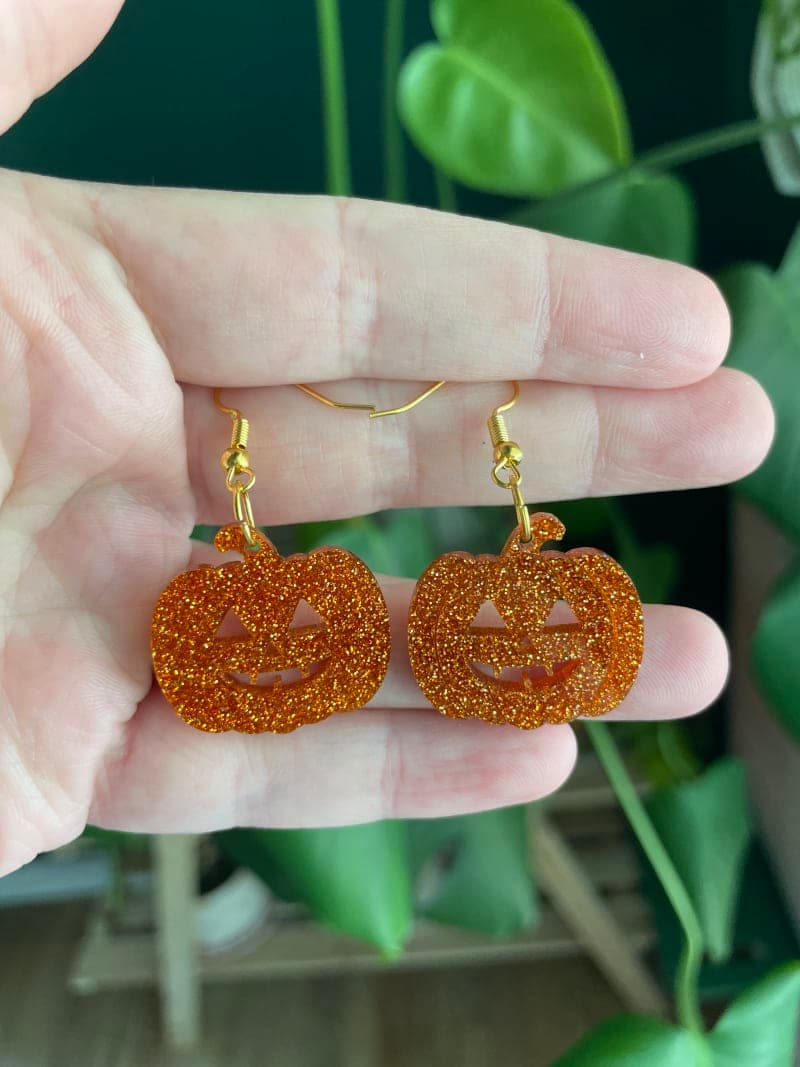 The selected image of Cute Glittery Acrylic Pumpkin Jack-o-Lantern Dangle Earrings